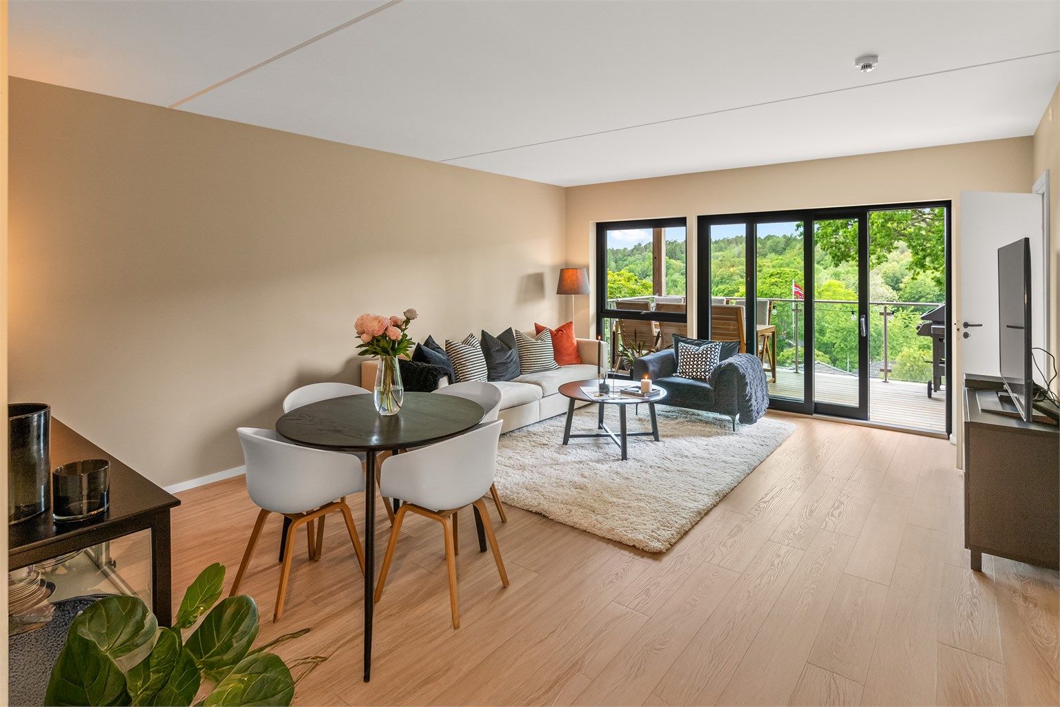 Stue med spiseplass og adkomst til balkong. 