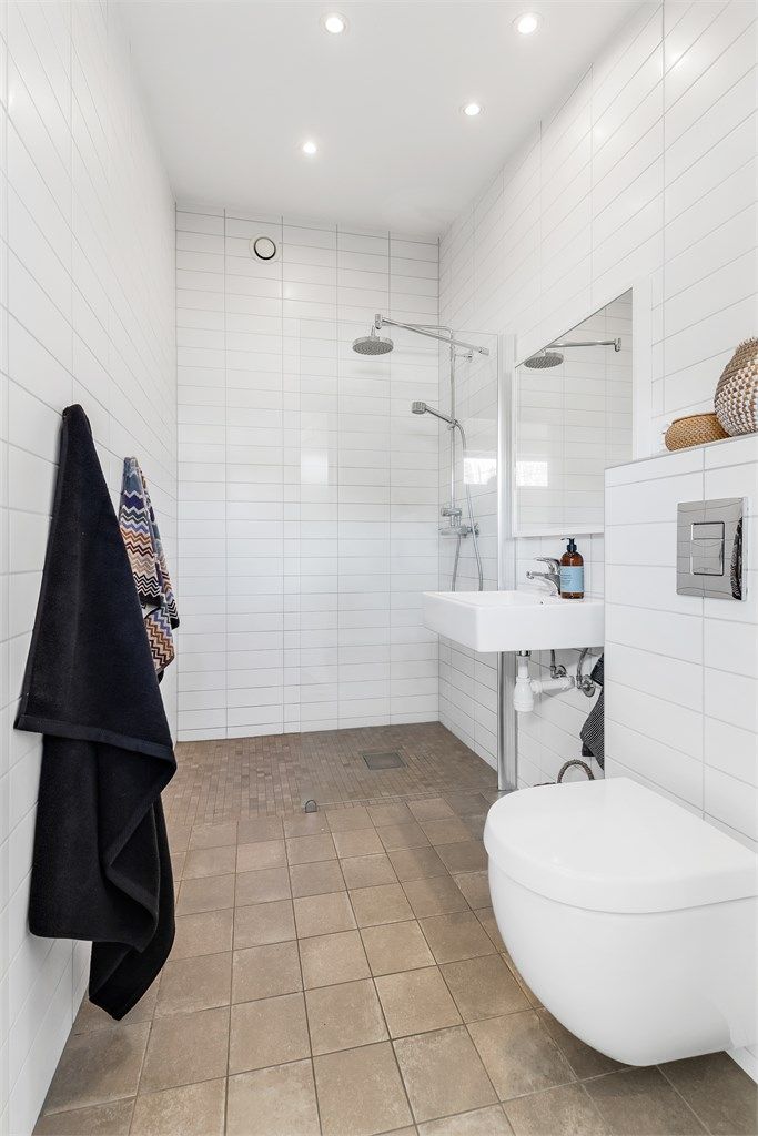 Baderom fra byggeår. Flislagt gulv med varme og flislagte vegger. Nedsenket himling med downlights. Vegghengt servant med ett-greps armatur. Speil på vegg over servant. Dusjsone med skillevegg i glass.