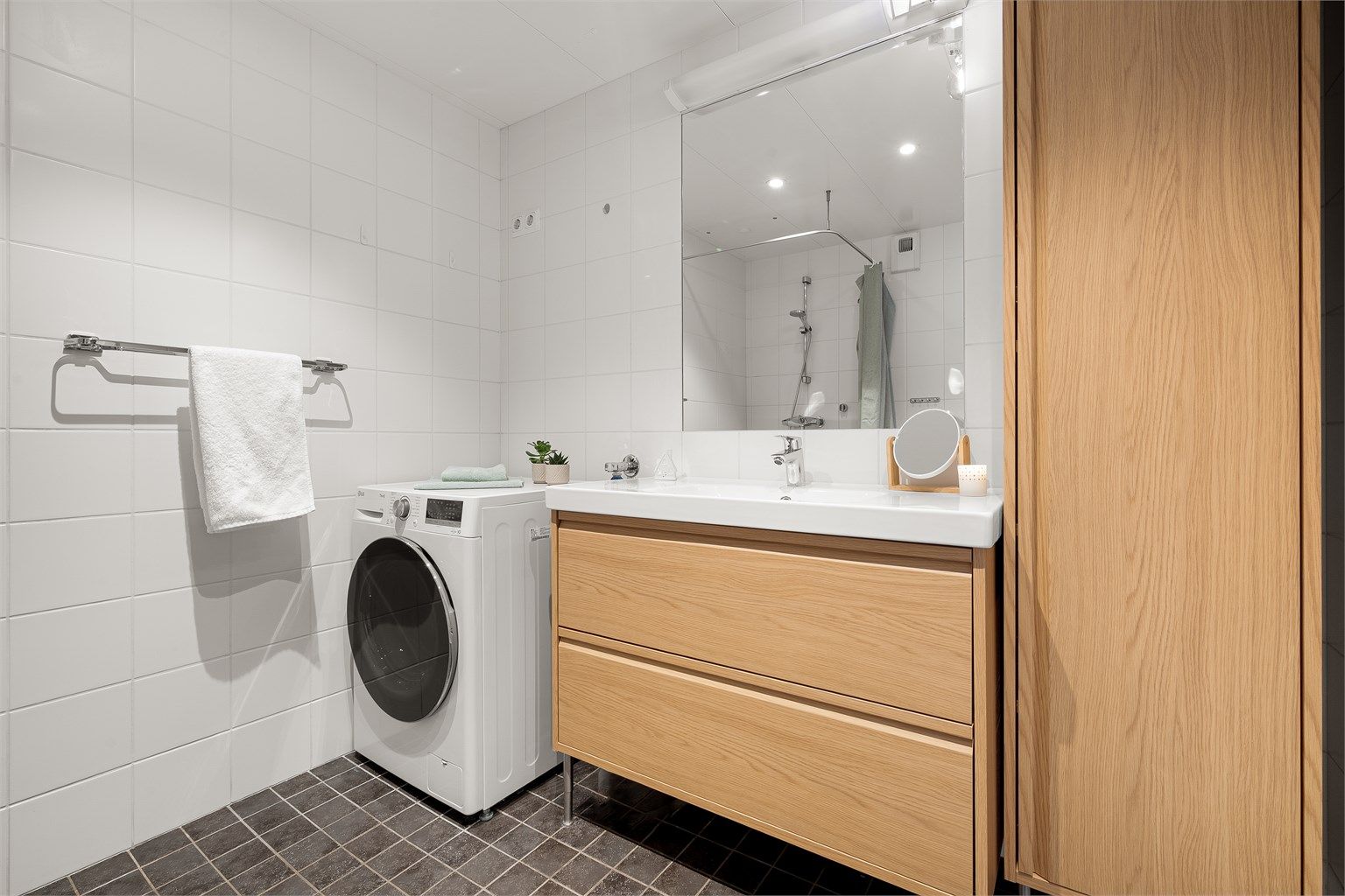 Ny baderomsinnredning og høyskap gir god oppbevaringsplass. Det er også opplegg for vaskemaskin.