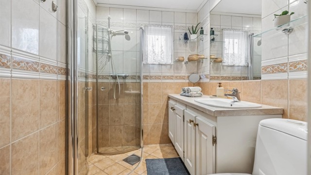 Flislagt bad med gulvvarme. Stor servantinnredning med god plass til oppbevaring. Dusjhjørne med innadslående glassdører samt gulvstående toalett.