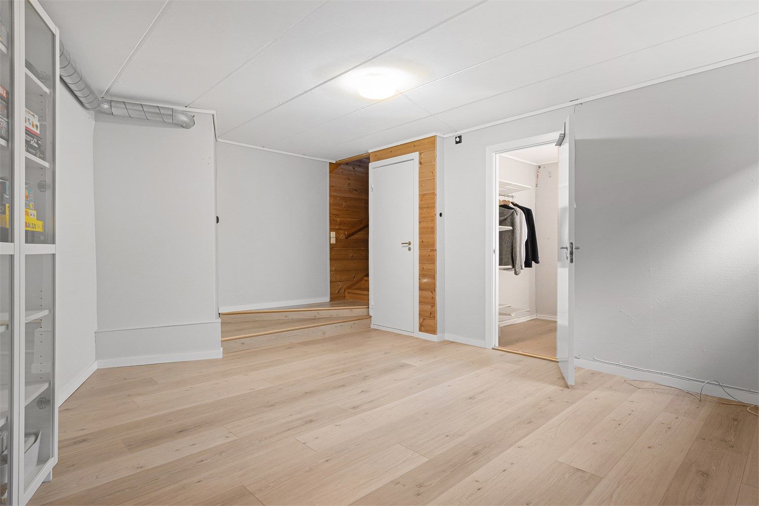Underetasjen har laminat på gulv, trappeadkomst og tilstøtende lagerrom. Herfra kan man åpne opp inn til hybeldel.