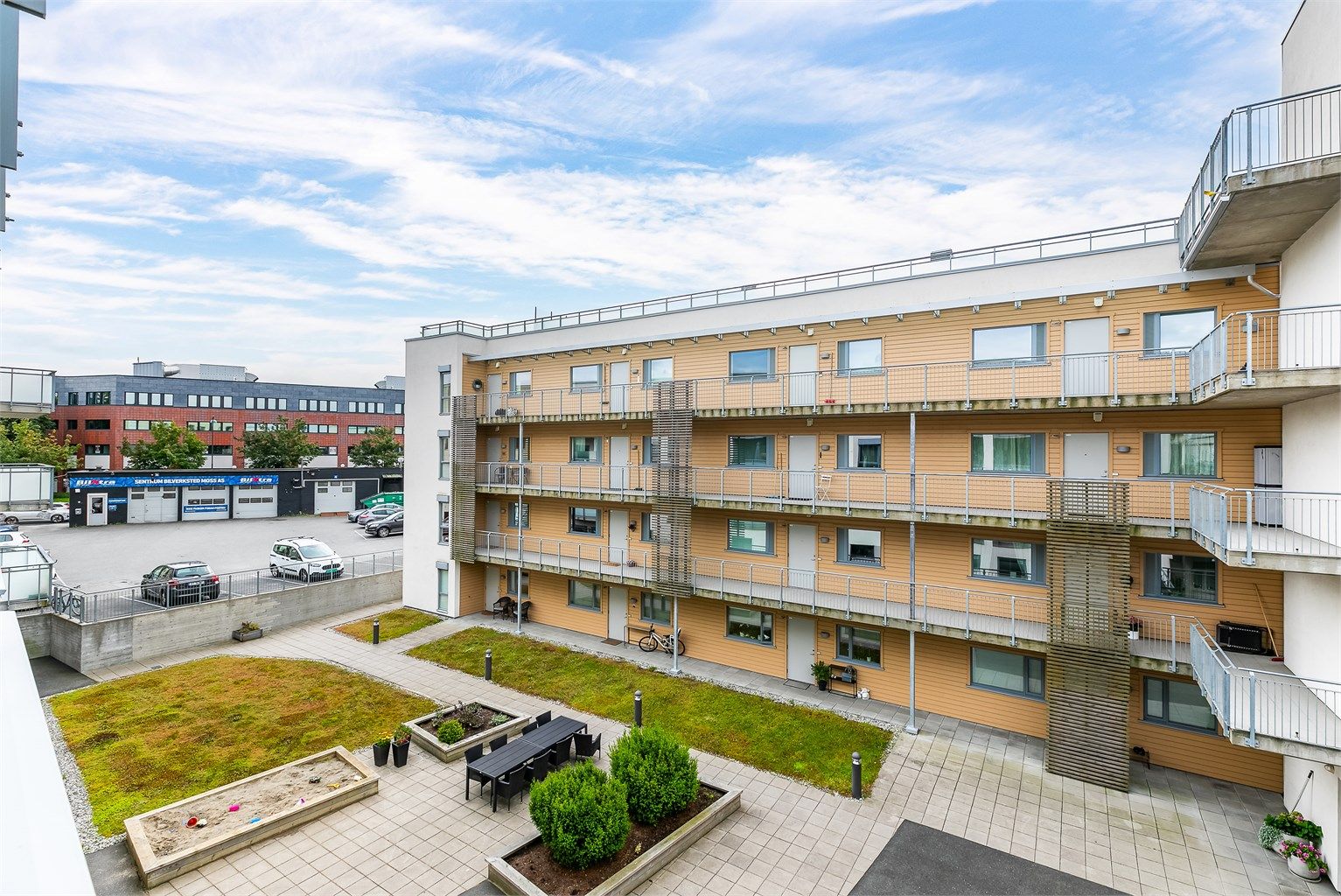 Utsyn fra verandaen over sameiets skjermede gårdsrom.