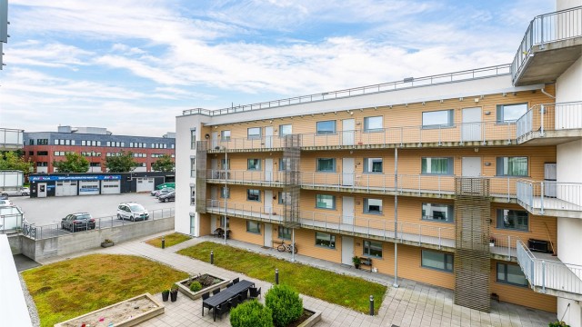 Utsyn fra verandaen over sameiets skjermede gårdsrom.