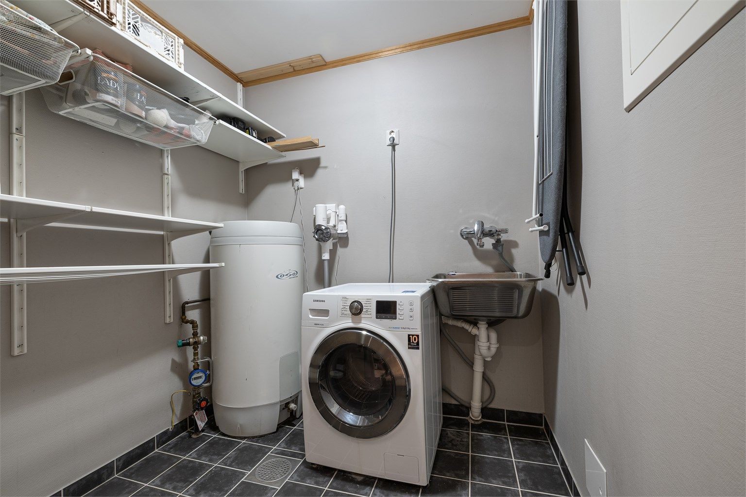 Separat vaskerom med flislagt gulv og praktisk plassering i tilknytning til entreen.