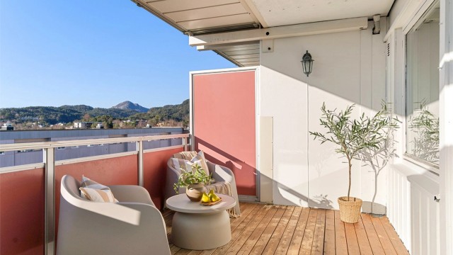 - Utsikt fra balkong. Plasseringen gjør at man kommer høyt nok opp i blokken til å få en langstrakt utsikt over bebyggelse foran og videre mot Lyderhorn -