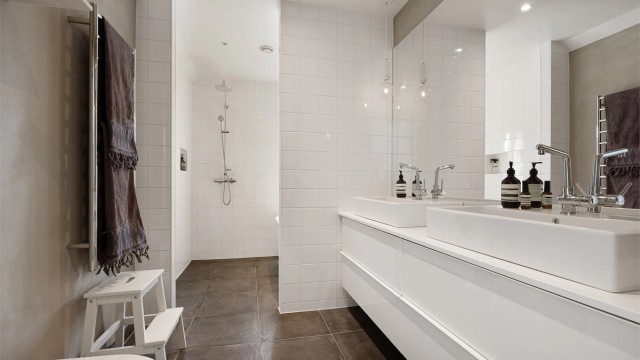 Romslig bad med både dusj på gulv og badekar.