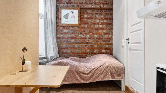 I hybeldelen er det plass til et lite spisebord samt sofa/seng i enden av rommet. Døren til høyre går inn til badet i hybelen.