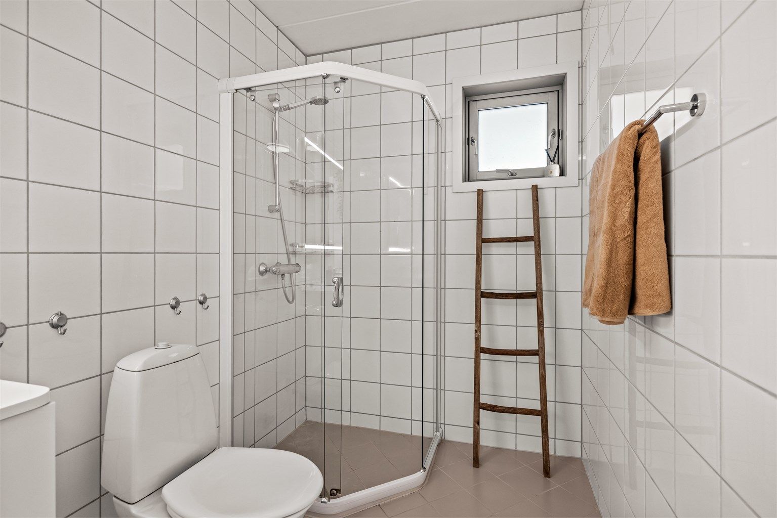 Flislagte gulv og vegger. Badet gir også rom for ekstra oppbevaring og løsninger etter eget behov.