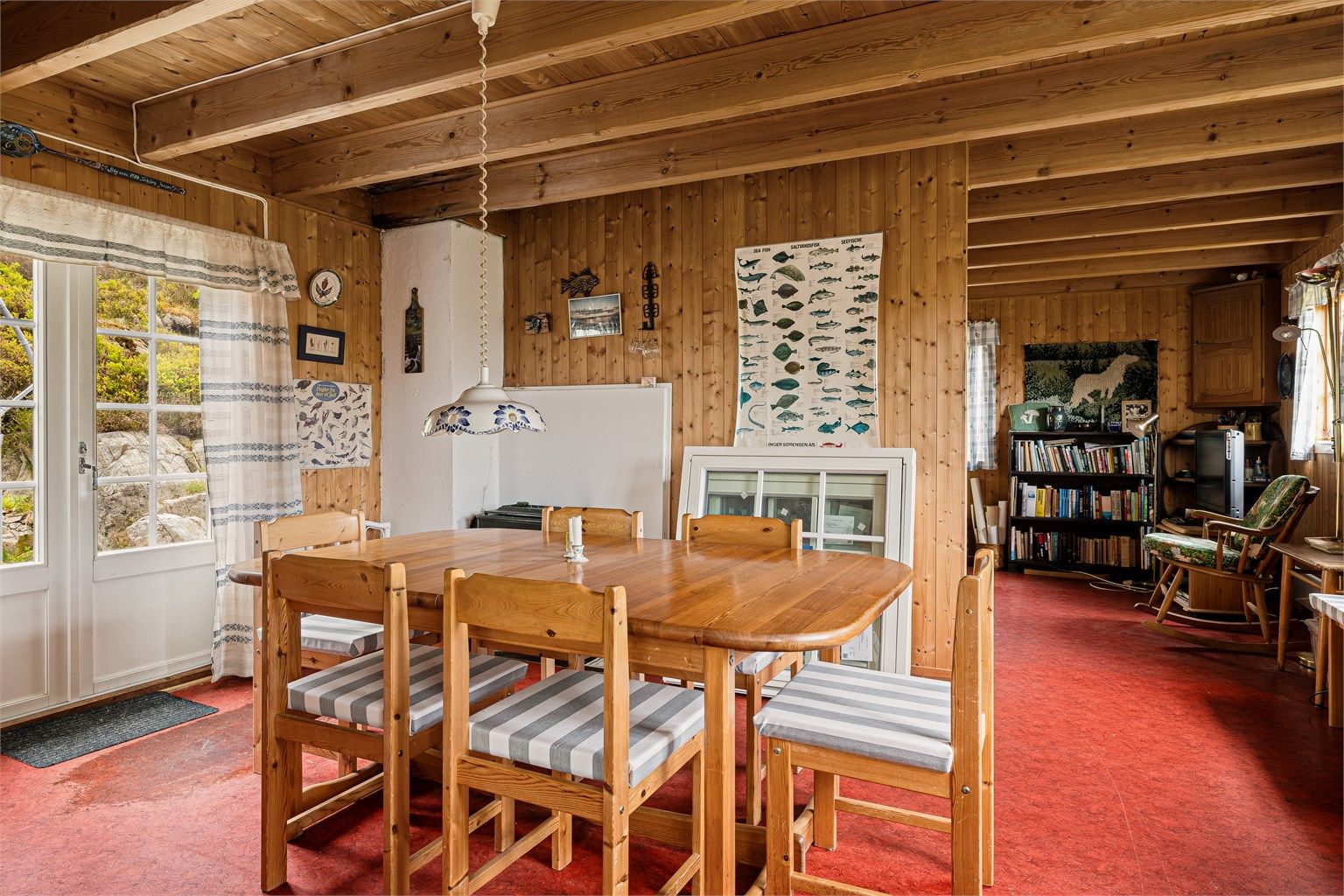 Fra spisestua er det utgang til uteplassen bak hytta. I hjørnet bak spisebordet er det en liten vedovn.