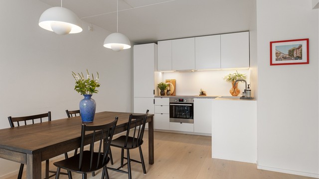 Et stilrent og moderne kjøkken med glatte fronter og integrerte hvitevarer. Den åpne løsningen gjør kjøkkenet til en naturlig del av det sosiale oppholdsrommet.