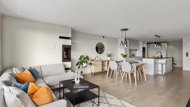 Rommet er holdt i lyse, moderne farger som står godt mot det lyse laminatgulvet. Det er lagt varmefolie i deler av stuen og kjøkkenet