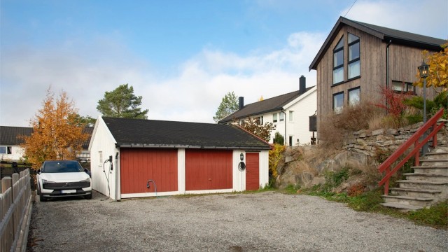 Felles garasjebygg med tilhørende bod og gruslagt parkeringsplass. Boligen disponerer uteplassen med EL-billader, ved siden av garasjen.