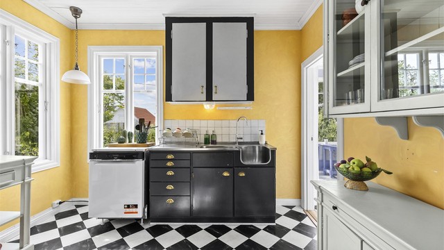 Kjøkkenet har innredning fra ukjent årstall med benkeplate i rustfritt stål og nedfelt oppvaskkum. Det er frittstående hvitevarer og vegghengt ventilator.