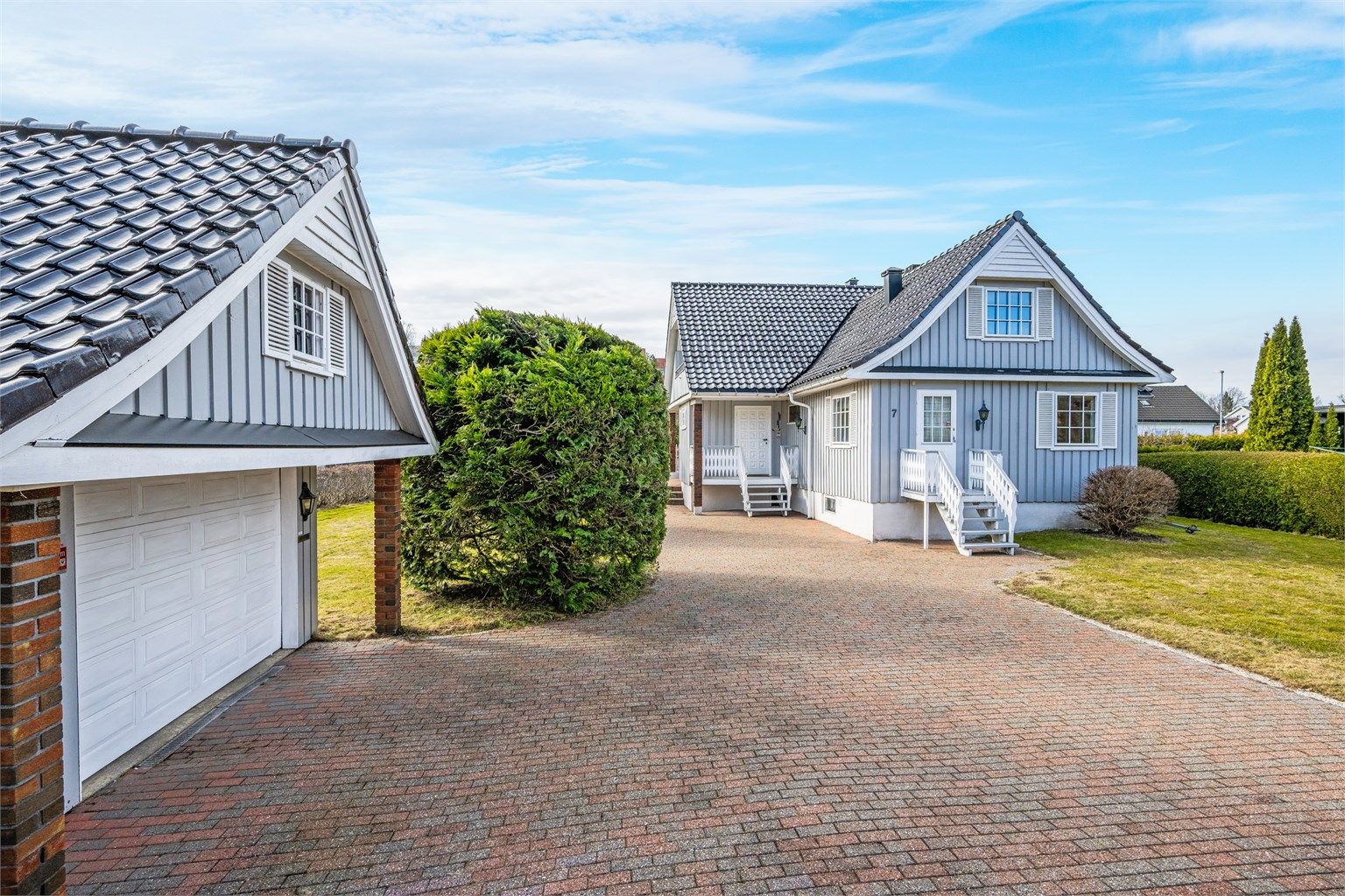 Eiendommen har en romslig, belegningssteinbelagt innkjørsel og en frittliggende garasje på 33 m².