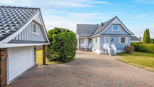 Eiendommen har en romslig, belegningssteinbelagt innkjørsel og en frittliggende garasje på 33 m².