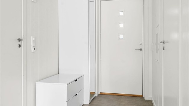 Flislagt entré med gulvvarme og entrédør med glassfelter. Garderobeskap som medfølger.