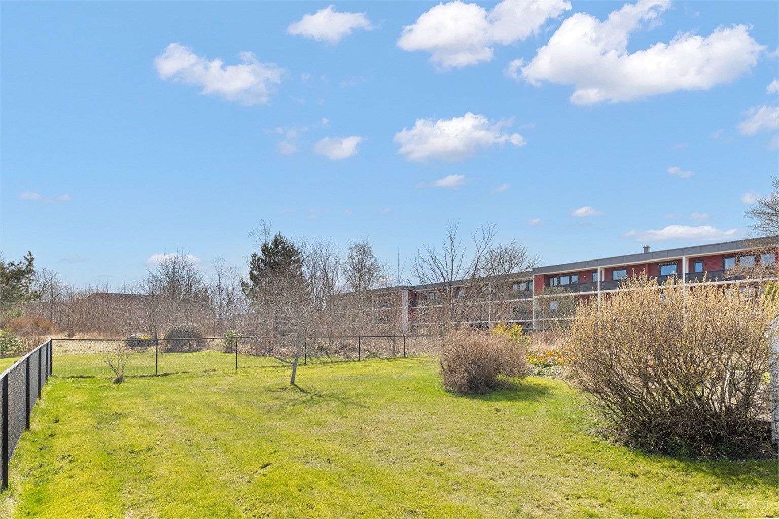 Hyggelig utsyn fra terrassen over store felles grøntarealer. 