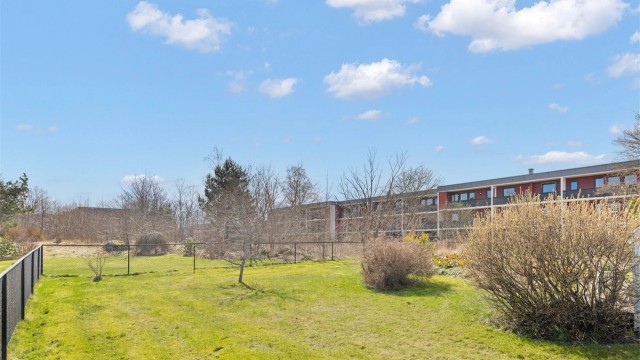 Hyggelig utsyn fra terrassen over store felles grøntarealer.