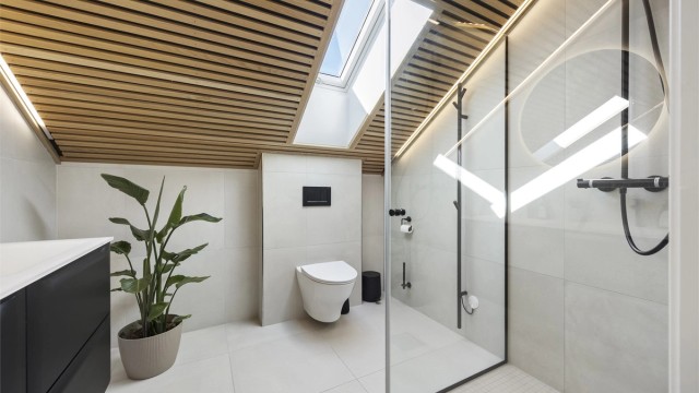 Badet i loftsetasjen ble etablert i 2021 og har et eksklusivt preg med spilehimling og takvindu.