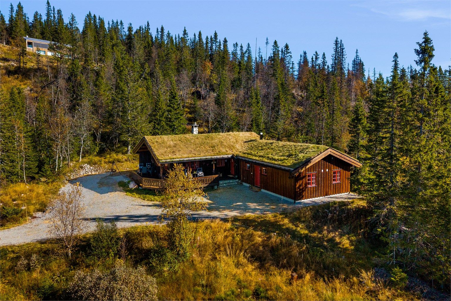 Hytta ligger usjenert til med bilvei helt frem og en romslig, gruslagt gårdsplass.