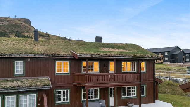 Leilighetsbygg fra 2005 med klassisk fjellarkitektur og overbygde balkongpartier.