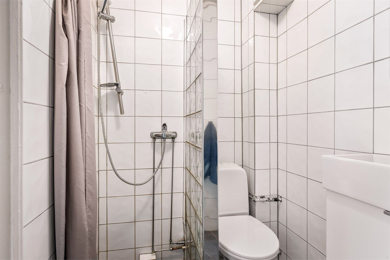 Badet har keramiske fliser på gulv og vegger.