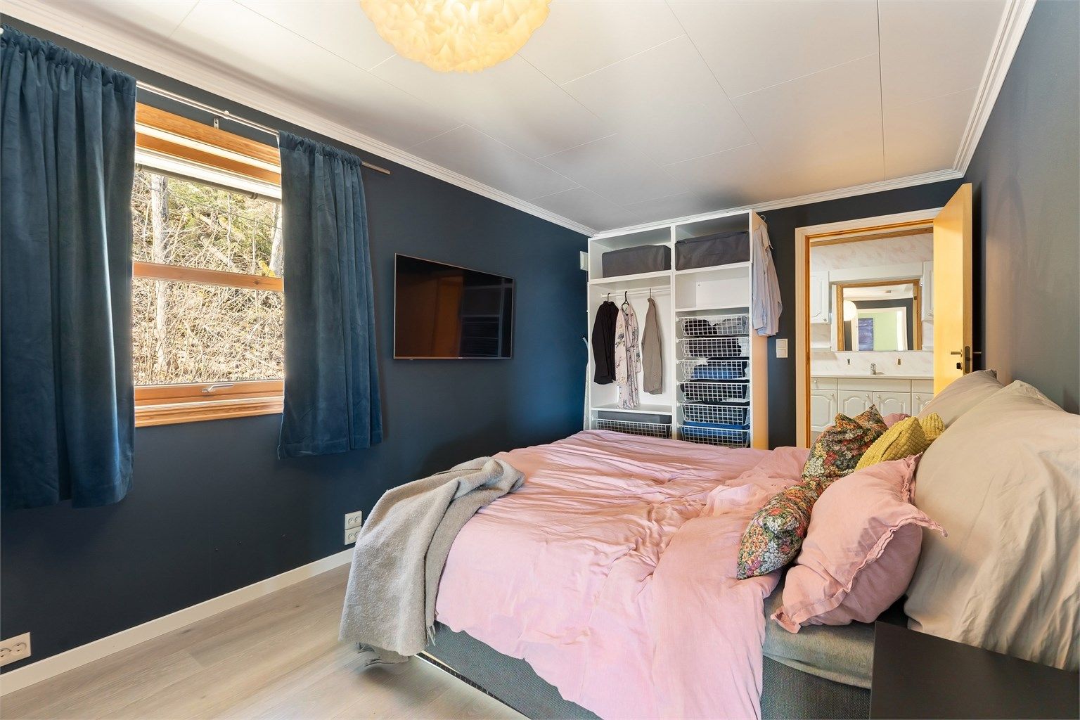 Soverommet har en praktisk, åpen garderobeløsning og adkomst til badet.