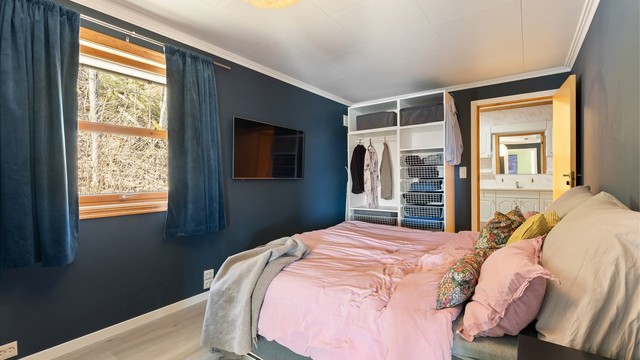 Soverommet har en praktisk, åpen garderobeløsning og adkomst til badet.