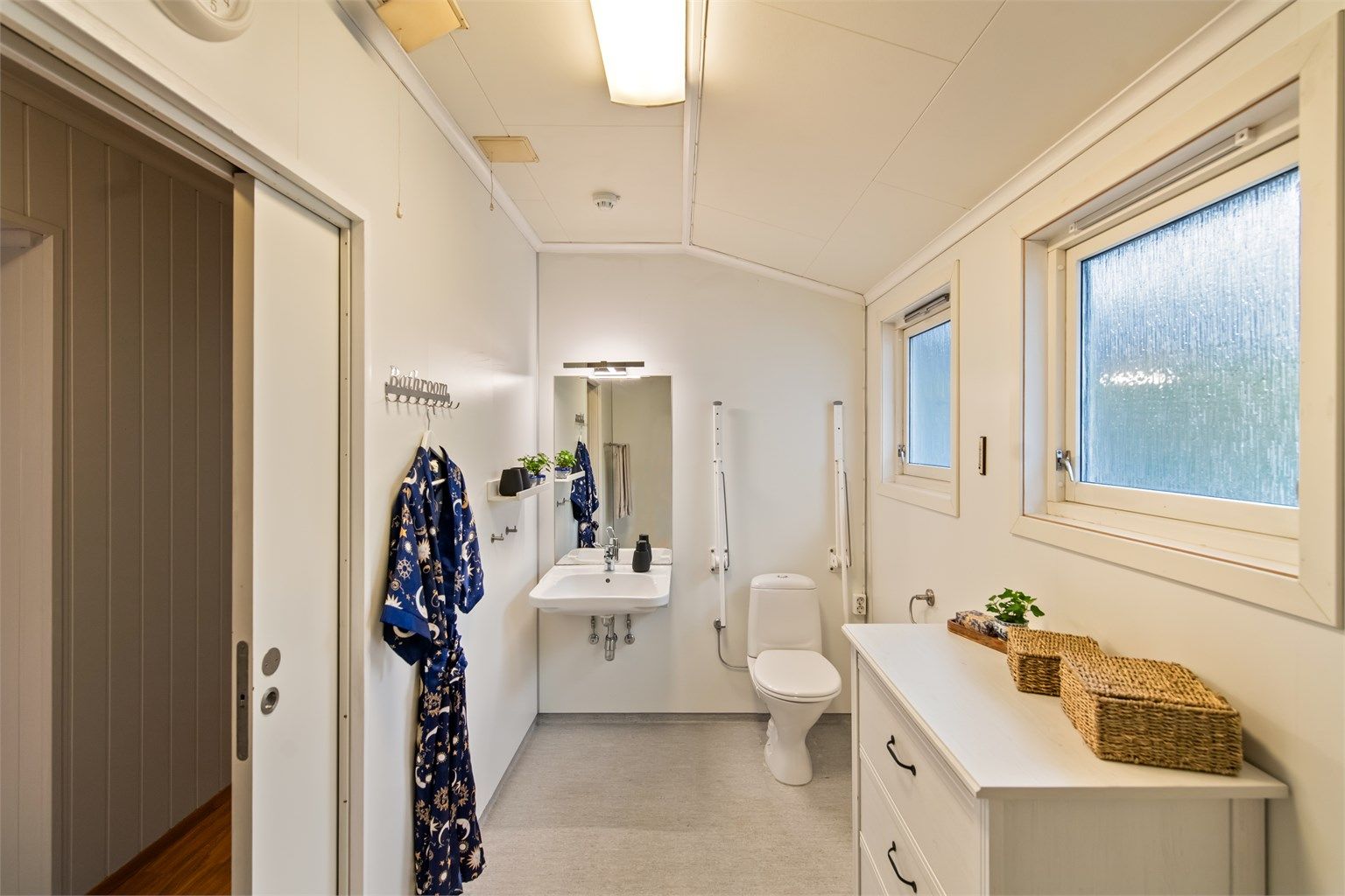 Badet i hovedetasjen har gulvbelegg og veggflater med baderomsplater. 