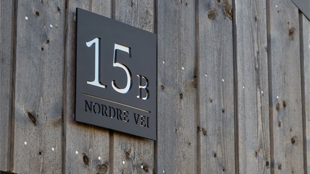 Fasade i stående trekledning med integrert belysning og gjennomførte detaljer.