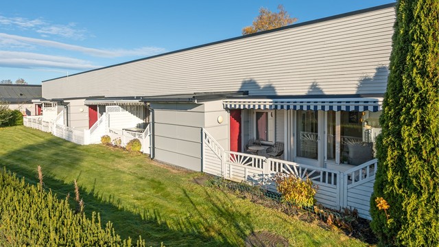 Bygningen er oppført over ett plan med grønne fellesarealer foran terrassene.