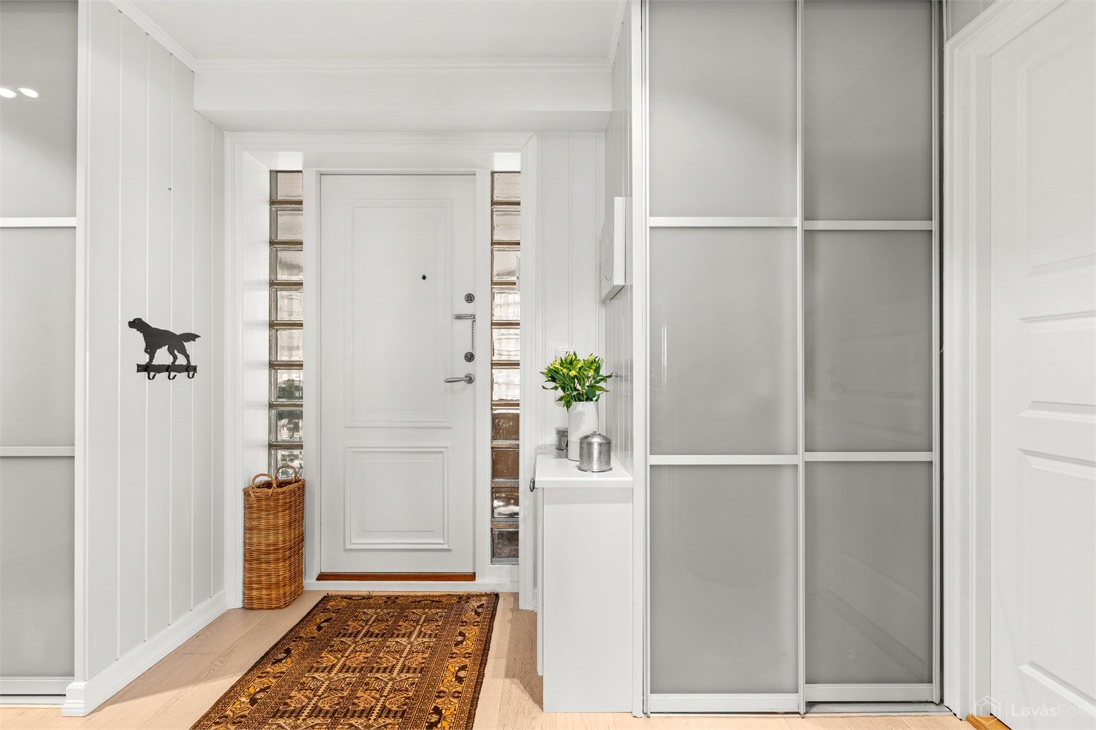 Romslig entré med gulvvarme og en stor skyvedørsgarderobe for effektiv oppbevaring av yttertøy.