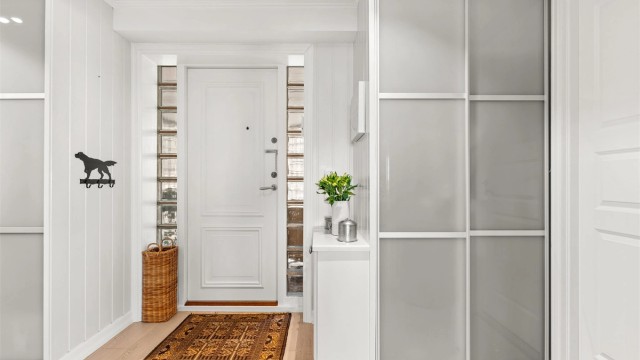 Romslig entré med gulvvarme og en stor skyvedørsgarderobe for effektiv oppbevaring av yttertøy.