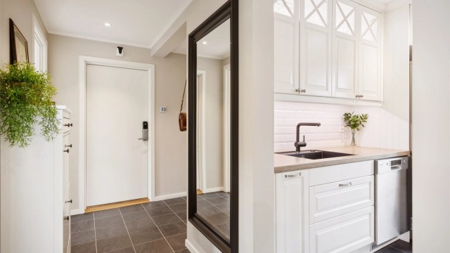 Lys og moderne gang med downlights, gulvvarme og gode oppbevaringsmuligheter - en naturlig og stilren overgang til boligens øvrige rom