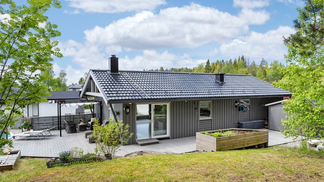 Baksiden av huset med utgang fra stuen til en markterrasse.