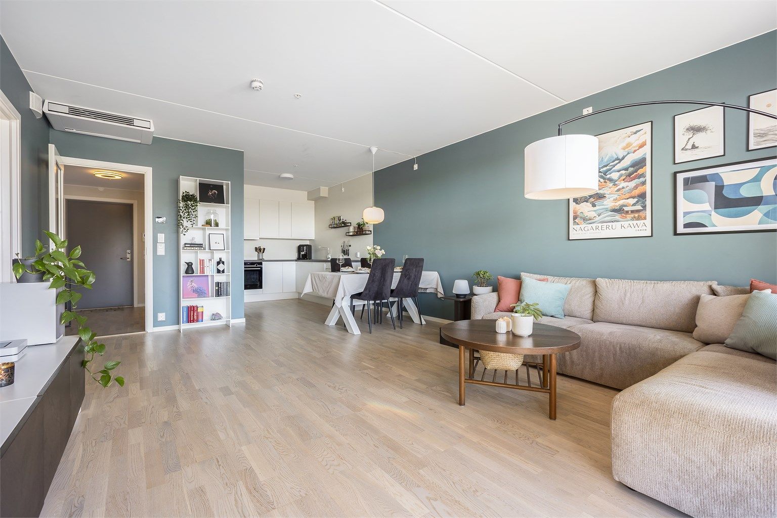 Den åpne løsningen mellom stue og kjøkken skaper en sosial og luftig sone med en takhøyde på 2,57 meter.