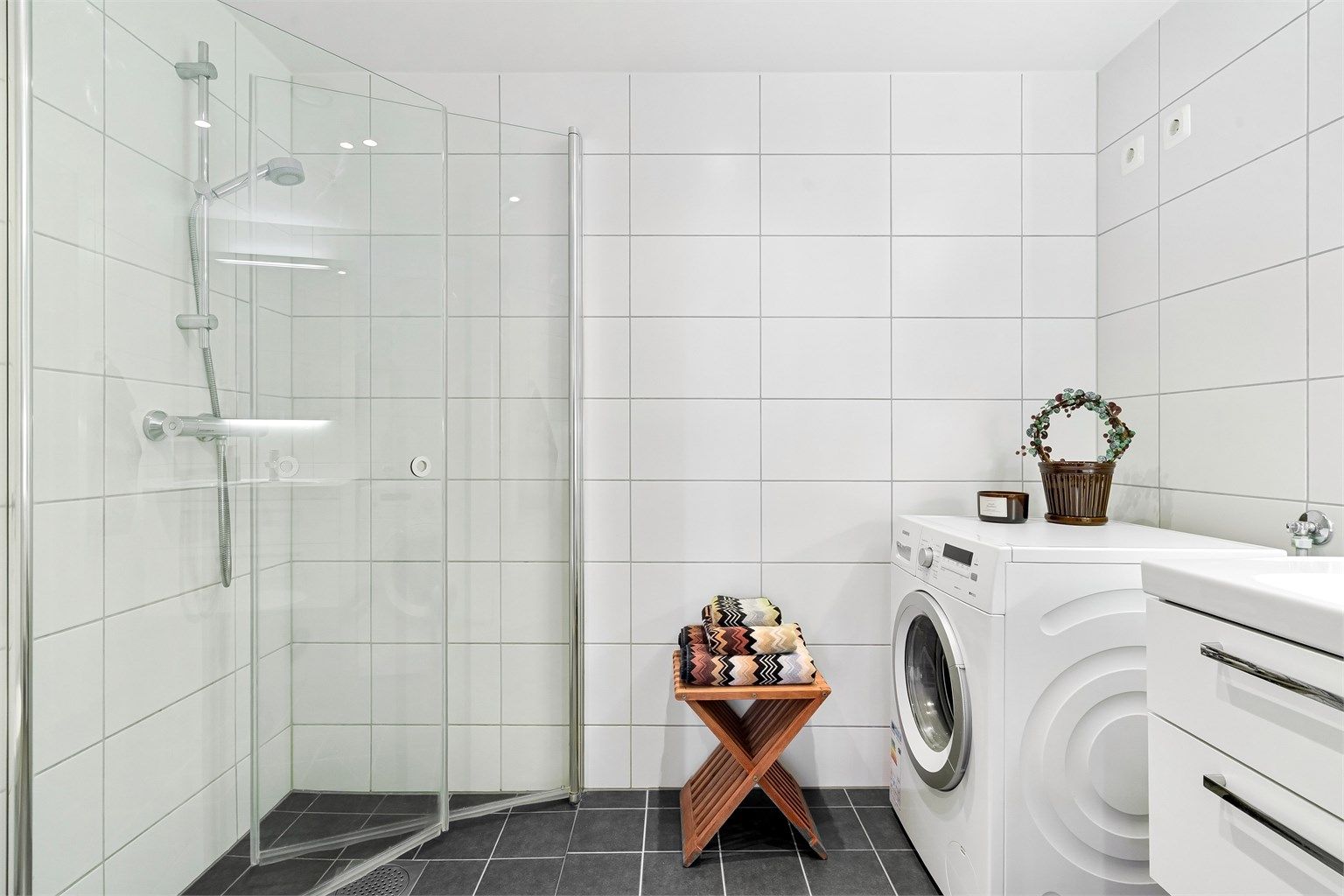 Dusjhjørnet har innfellbare glassdører som frigjør gulvplass når dusjen ikke er i bruk.