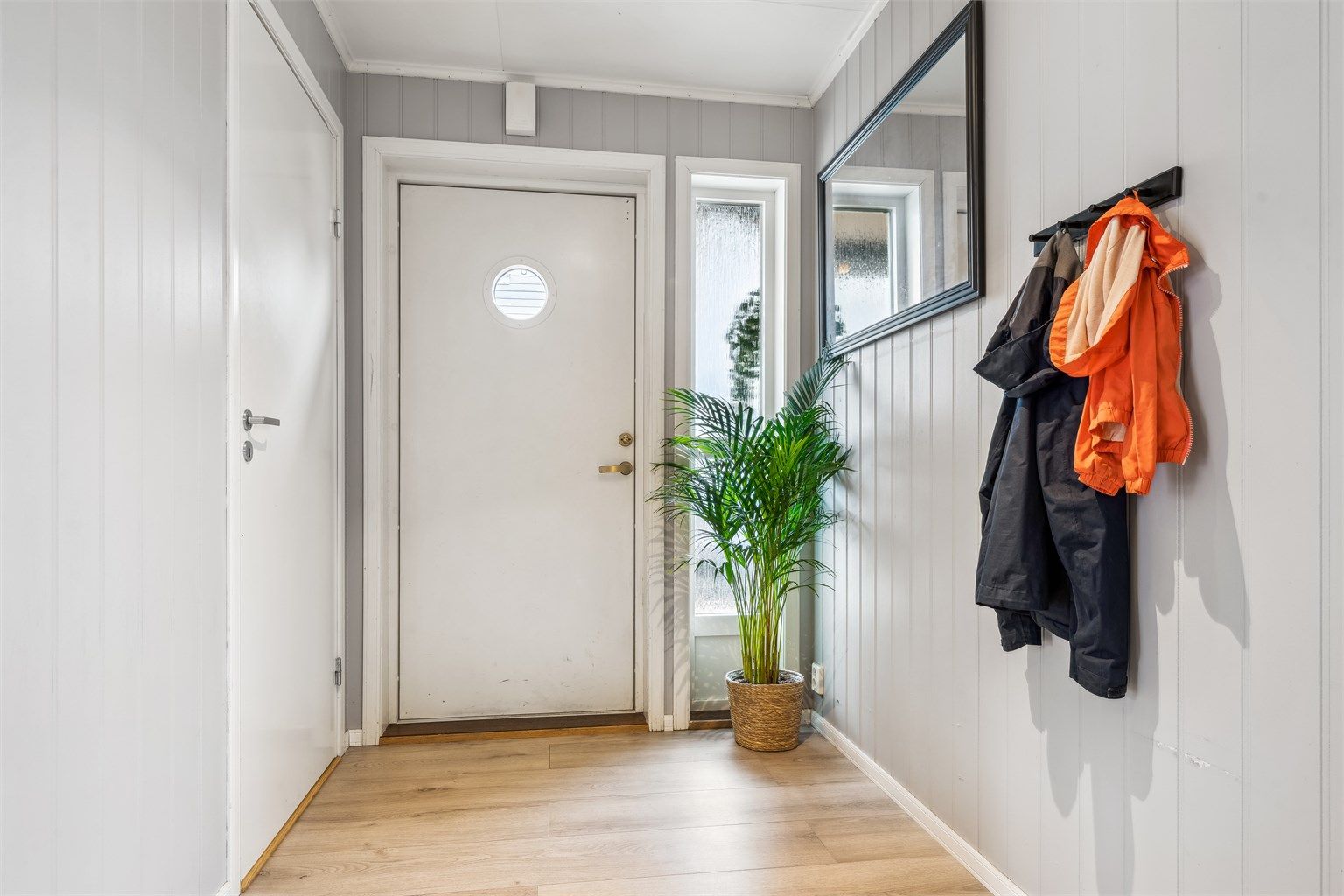 Velkommen inn i lys entré med praktisk adkomst til bod som byr på øvrig lagringsplass