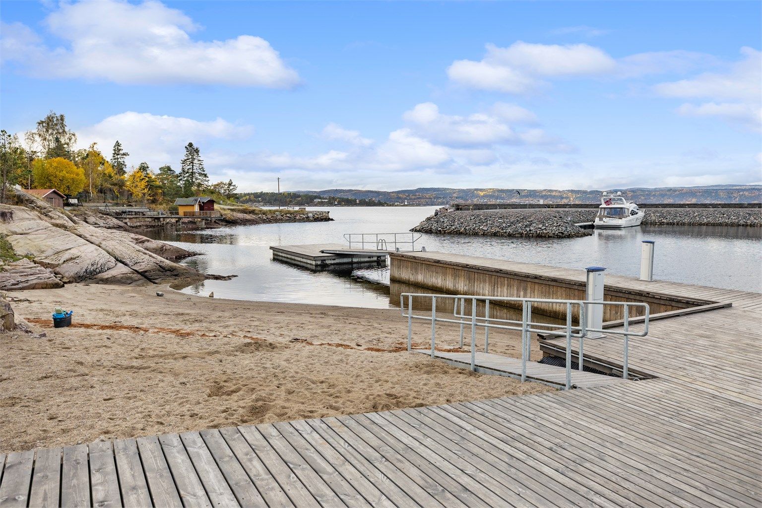 Badebrygge og sandstrand tilrettelagt for badeliv gjennom sommerhalvåret.