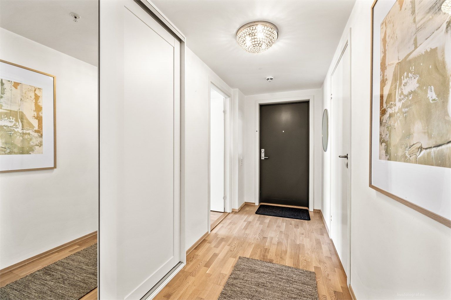 Entré med skyvedørsgarderobe i hvit og profilert utførelse samt speilfront.