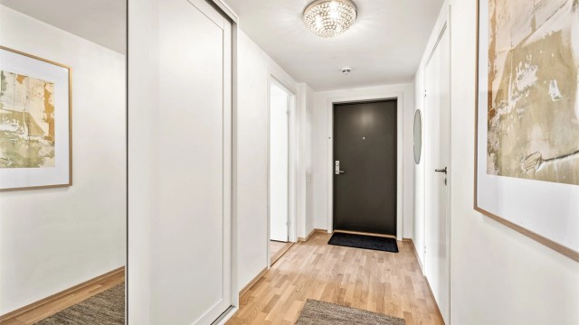 Entré med skyvedørsgarderobe i hvit og profilert utførelse samt speilfront.