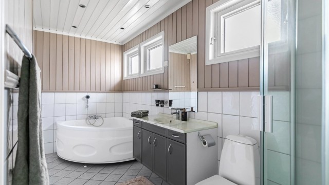 Stort og dels flislagt baderom med gulvvarme og downlights i himling