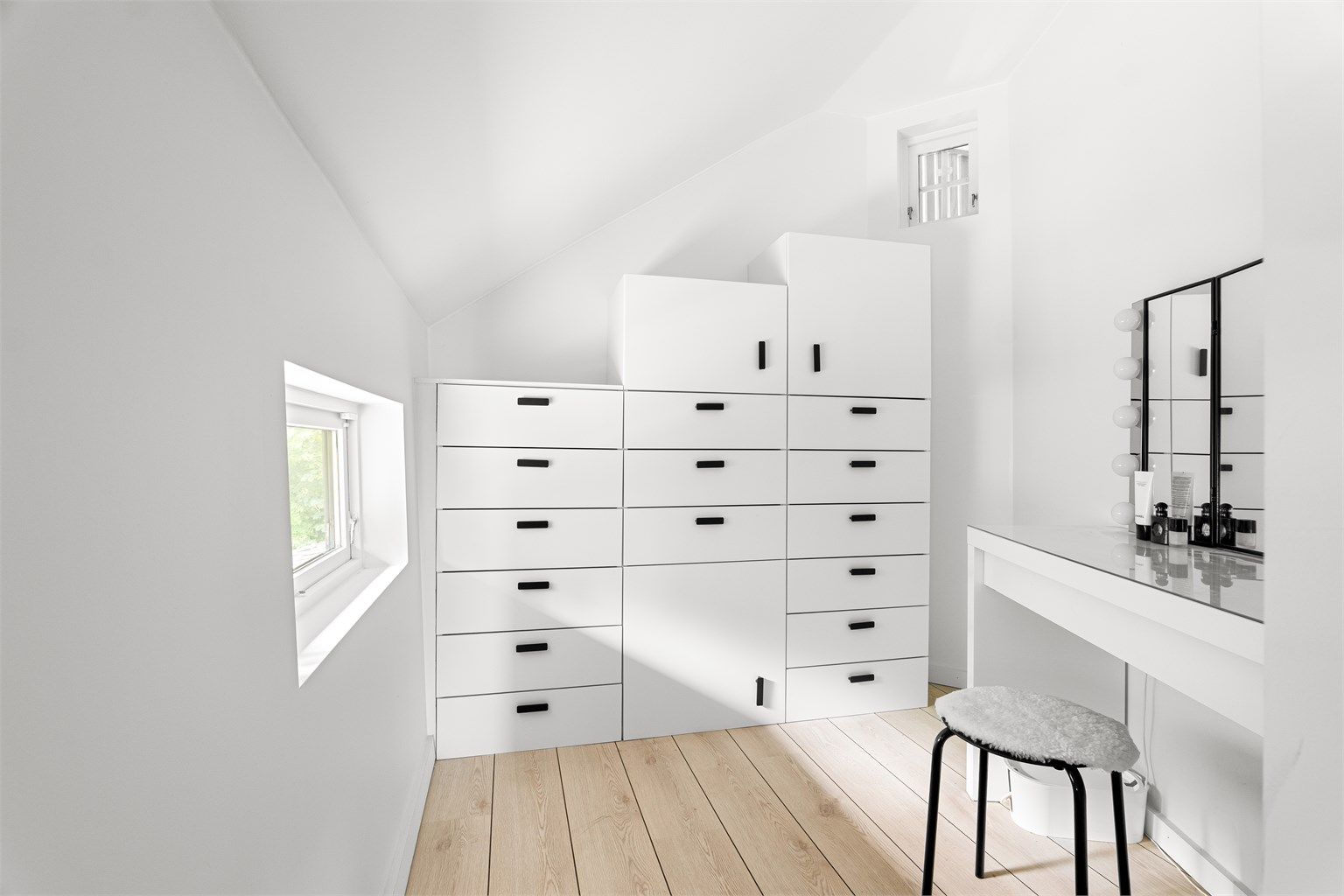 Tilbaketrukken del av mellomgangen, med rom for oppbevaringsløsninger og sminkebord.
