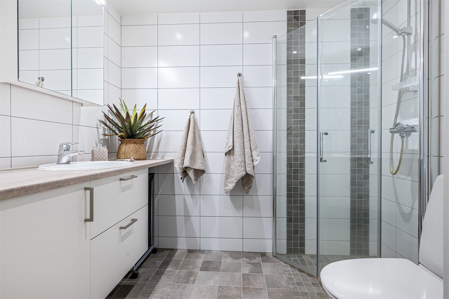 Det andre badet har også flislagt gulv med gulvvarme samt flislagte vegger.