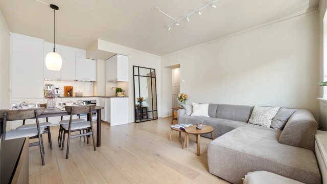 Leiligheten inneholder en åpen stue- og kjøkkenløsning, entré, soverom, og flislagt bad. Fra stuen er det utgang til balkong med plass til sittegruppe og bord. Foto: Marit Andersen.