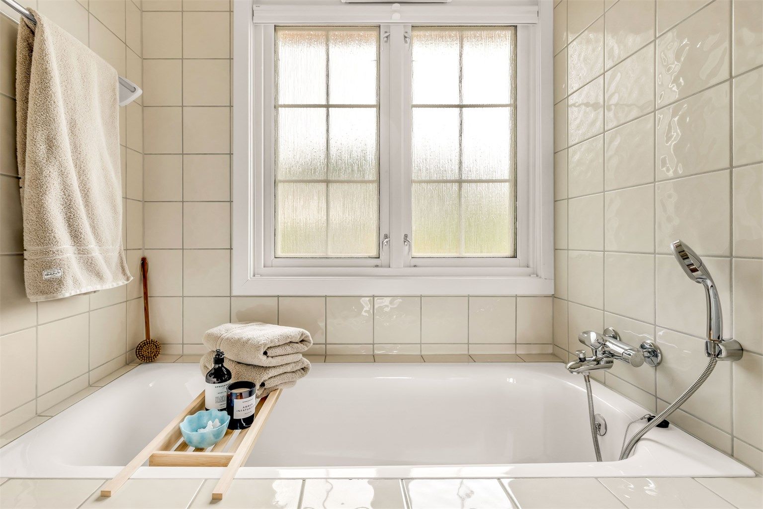 Badet har innmurt badekar med badekararmatur tilkoblet hånddusj.