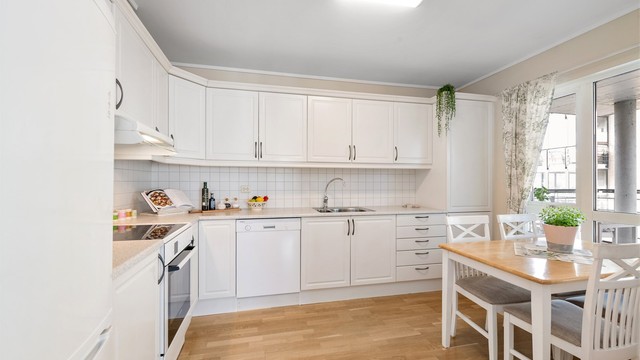 Kjøkkeninnredning fra byggeåret med profilerte fronter, laminatbenkeplate og god skapplass.