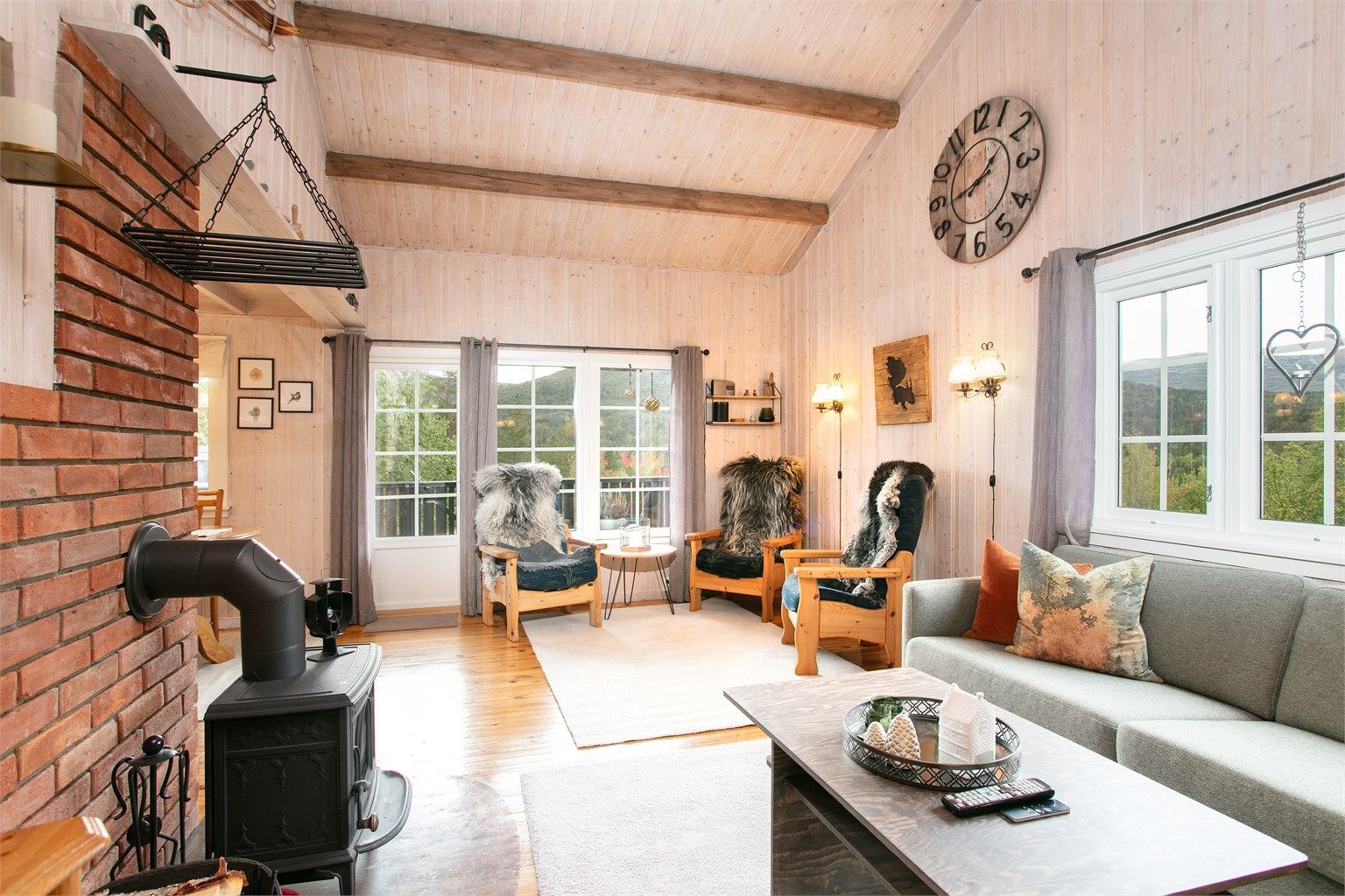 Stuen har åpen himling med god takhøyde og en lun vedovn.
Foto: Jarle Osen