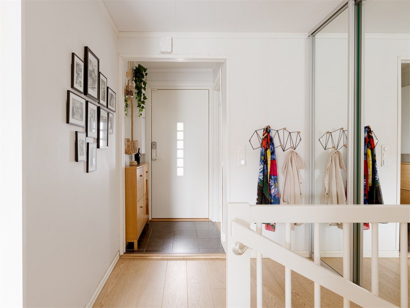 Boligens 1. etasje er utrustet med en innbydende entré med fliser på gulv med gulvvarme. God plass til yttertøy i skyvedørsgarderobe. 