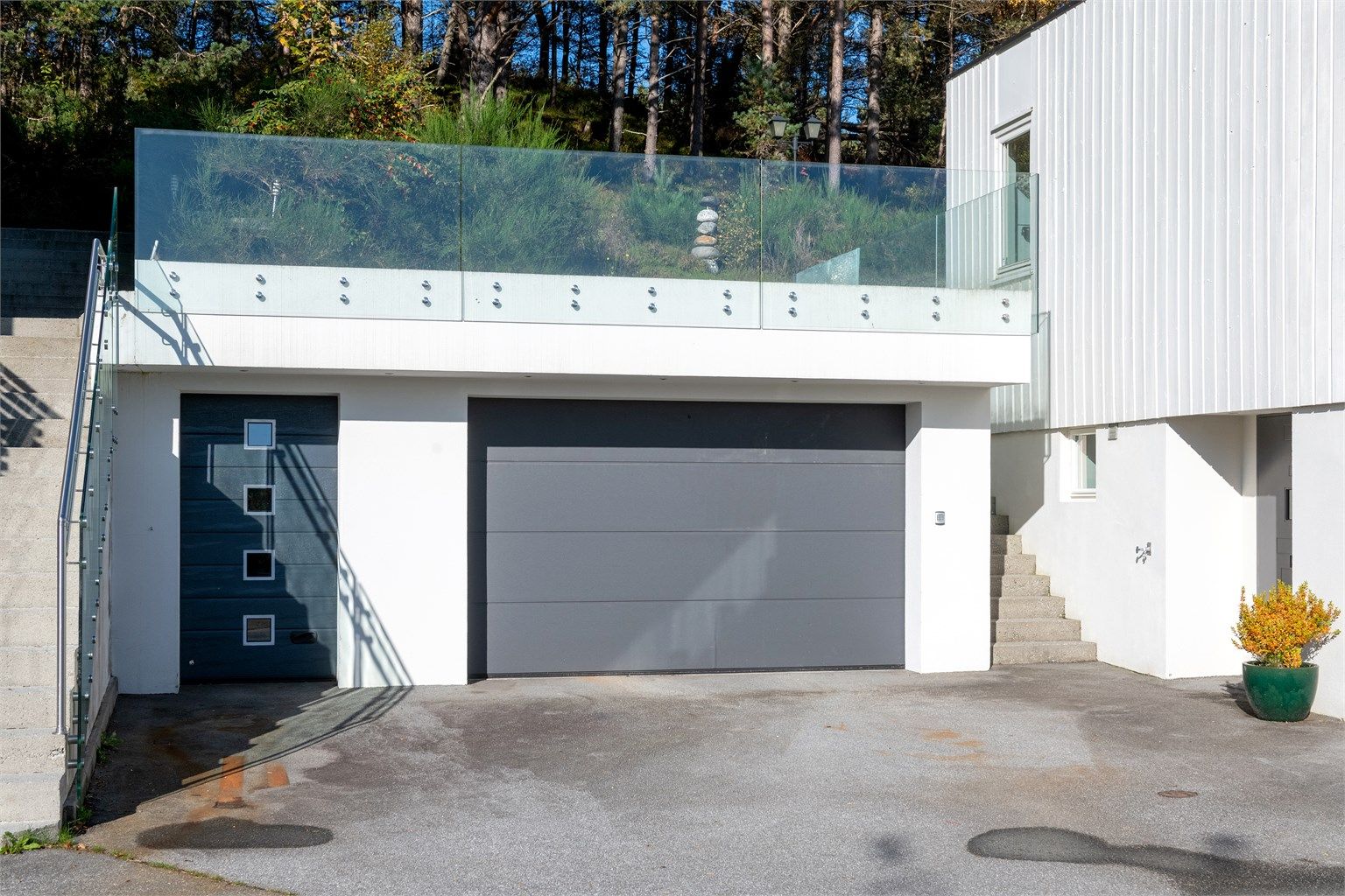 Frittstående garasje fra 2014 oppført i mur og betong, med gresstak, leddport og innlagt strøm.